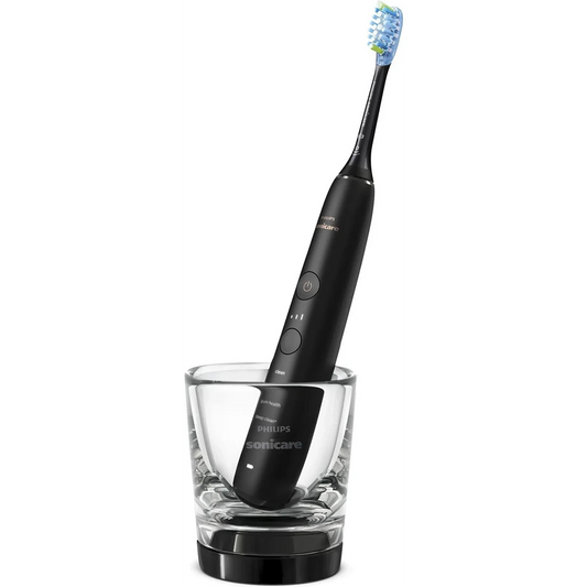 Die Philips DiamondClean 9000 HX9913/18 Schallzahnbürste in Schwarz steht aufrecht im Glas-Ladebecher - von Philips, für effektive Plaque-Entfernung und elegantes Design.