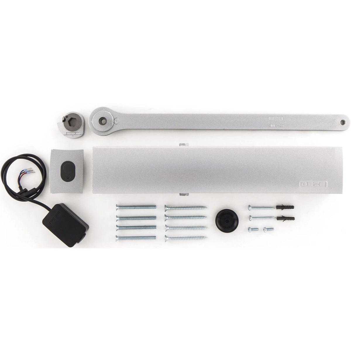 Ein GEZE Türschließer TS 5000 E-Hy EN 3-6 mit Freilauffunktion, in silber, mit Montagearm, Abdeckung, Schrauben, schwarzen Kunststoffteilen, Wandschalter und Verdrahtung - ideal für Feuer- und Rauchschutztüren - auf weißem Hintergrund.