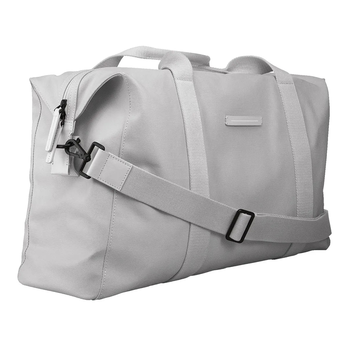 Die Horizn Studios SoFo Weekender M in Light Quartz Grey ist eine nachhaltige Reisetasche aus recycelter Baumwolle mit zwei Henkeln, einem abnehmbaren, verstellbaren Schultergurt und einer seitlichen Reißverschlusstasche, die schräg auf weißem Grund steht.