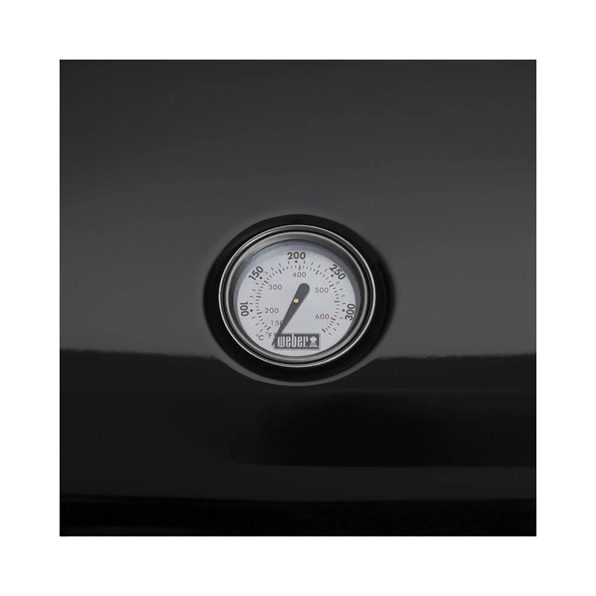 Ein rundes Thermometer auf dem schwarzen Deckel des Weber Lumin Compact von Weber zeigt die Temperatur in Grad Fahrenheit an.