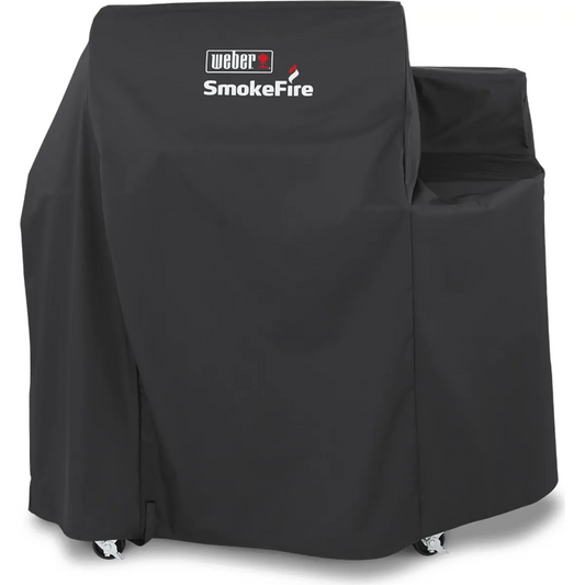 Die Weber Premium 7192 Abdeckhaube in Schwarz ist hier aus der Frontalansicht zu sehen, wie sie einen SmokeFire EX4-Grill bedeckt, wobei die Räder unten sichtbar sind – diese Grillabdeckung von Weber sorgt für zuverlässigen Schutz und eine stilvolle Optik.