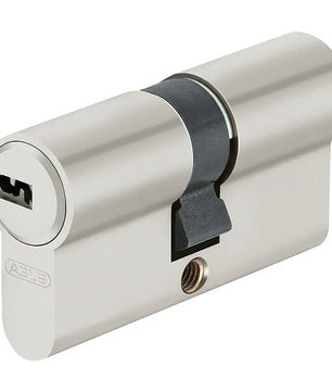 Das silberne Doppelzylinderschloss ABUS Profilzylinder D6X 50/60 verfügt über einen Anti-Picking-Schutz, ein Schlüsselloch und einen schwarzen Drehnocken in der Mitte, dargestellt auf weißem Hintergrund.