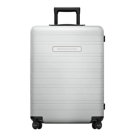 Der Horizn Studios H6 Essential 4-Rollen Trolley (64 cm) in Silber von Horizn Studios verfügt über einen Polycarbonat-Hartschalenkorpus, einen Teleskopgriff, vier Rollen und ein TSA-Zahlenschloss - präsentiert vor weißem Hintergrund.
