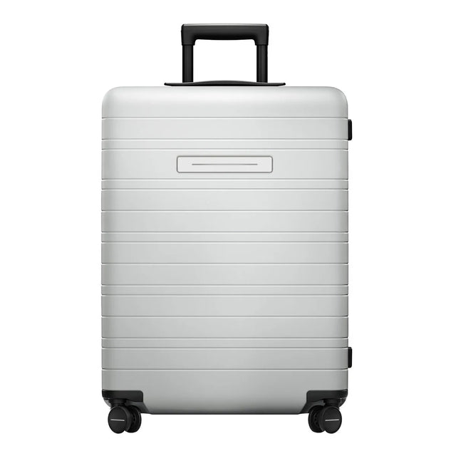 Der Horizn Studios H6 Essential 4-Rollen Trolley (64 cm) in Silber von Horizn Studios verfügt über einen Polycarbonat-Hartschalenkorpus, einen Teleskopgriff, vier Rollen und ein TSA-Zahlenschloss - präsentiert vor weißem Hintergrund.