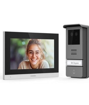 Das Thomson Smart Face Video-Türsprechanlagensystem von Thomson zeigt eine lächelnde Frau auf dem Bildschirm und verfügt über eine Türklingel mit der Aufschrift „Mr. Dupuis“ sowie eine biometrische Zugangskontrolle.