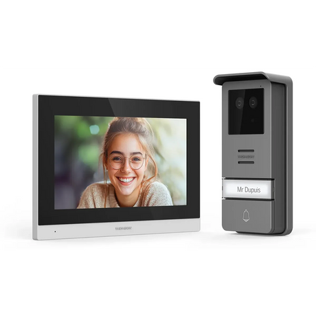 Das Thomson Smart Face Video-Türsprechanlagensystem von Thomson zeigt eine lächelnde Frau auf dem Bildschirm und verfügt über eine Türklingel mit der Aufschrift „Mr. Dupuis“ sowie eine biometrische Zugangskontrolle.