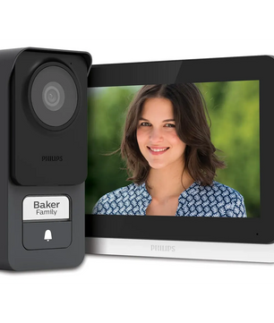 Eine Philips WelcomeEye Lite 2 Video-Türsprechanlage – schwarz – und ein Innendisplay zeigen eine lächelnde Frau; auf der Türklingel steht „Baker Family“, was den Komfort des integrierten RFID-Lesegeräts von Philips verdeutlicht.