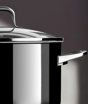 Eine Nahaufnahme des WMF Topfset 4-tlg. Fusiontec Essential Pro, einem glänzend schwarz-silbernen Kochtopf mit Deckel und Griff von WMF, hergestellt aus dem langlebigen Fusiontec-Material, vor einem dunklen Hintergrund.