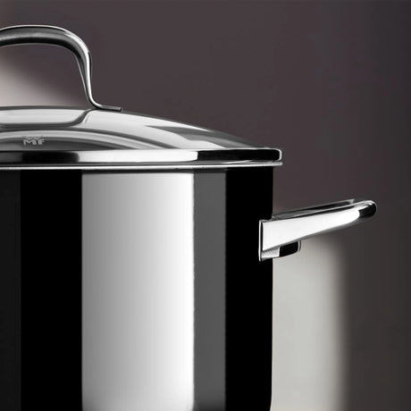 Eine Nahaufnahme des WMF Topfset 4-tlg. Fusiontec Essential Pro, einem glänzend schwarz-silbernen Kochtopf mit Deckel und Griff von WMF, hergestellt aus dem langlebigen Fusiontec-Material, vor einem dunklen Hintergrund.