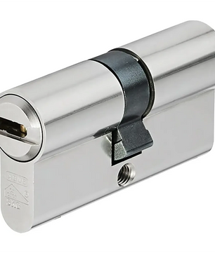 Der ABUS XD25 40/40 Profilzylinder in Silber wird aus einem Winkel mit einem Schlüsselloch vor einem weißen Hintergrund gezeigt.