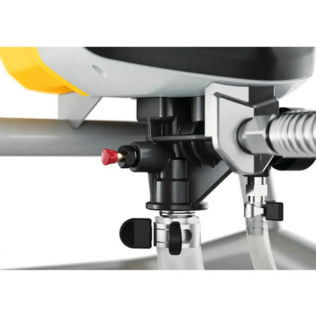 Nahaufnahme von Maschinenteilen mit Rohren, einem roten Knopf und Metallverbindungsstücken, bestehend aus Komponenten des Wagner HEA Control Pro M275 Farbsprühsystems – gelb von Wagner, das die innovative HEA-Airless-Technologie nutzt.