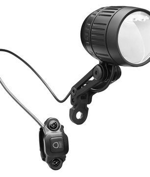 Der Busch & Müller Lumotec IQ-XM Dynamoscheinwerfer in schwarz, mit Halterung und kabelgebundenem Fernschalter, verfügt über Fernlichtfunktion und StVZO-Zulassung. Abgebildet ist er vor weißem Hintergrund.