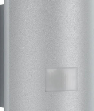 Die Steinel L 910 LED-Sensor-Außenleuchte in Grau ist eine moderne Wandleuchte mit einem eleganten silbernen Band und weißen Akzenten an der Ober- und Unterseite. Sie wurde für eine stilvolle Beleuchtung konzipiert, eignet sich ideal für moderne Räume und verbindet Form und Funktion nahtlos miteinander – ganz im Sinne der bekannten Steinel-Qualität.