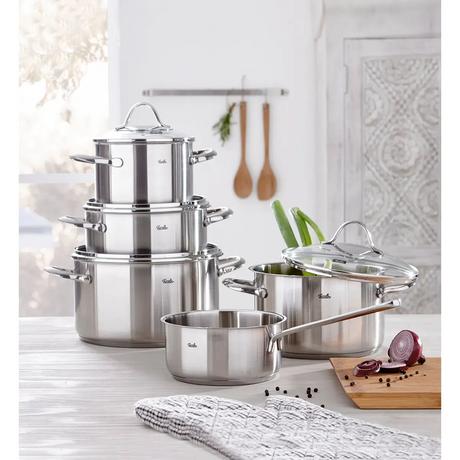 Das Fissler Topf-Set PARIS 5-teilig aus Edelstahl steht induktionstauglich auf der Küchenarbeitsplatte - daneben frisches Gemüse und Kochutensilien.
