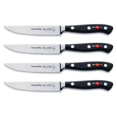 Vier identische Friedr.Dick F. DICK Premier Plus Steakmesser mit schwarzen Griffen und silbernen Klingen, horizontal auf weißem Hintergrund angeordnet.