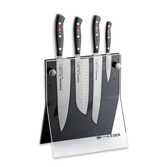 Auf einem transparenten Ständer mit Friedr.Dick-Branding werden vier Küchenmesser aufrecht stehend präsentiert, darunter der Friedr.Dick Premier Plus Messerblock 4 tlg - schwarz, ein vierteiliges Premium-Messer-Set mit hochwertigen geschmiedeten Klingen.
