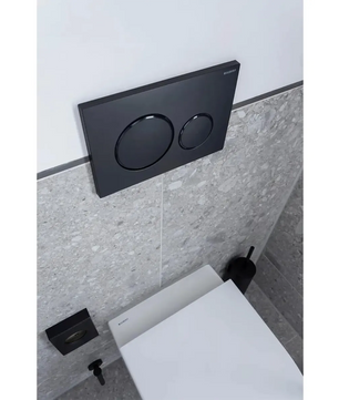 Modernes WC, ausgestattet mit einer Geberit Sigma 20-Betätigungsplatte in elegantem Schwarz, auf der zwei runde Spültasten über dem geschlossenen Deckel zu sehen sind.