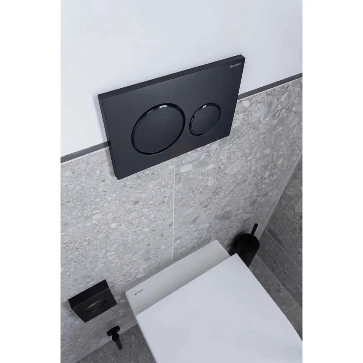 Modernes WC, ausgestattet mit einer Geberit Sigma 20-Betätigungsplatte in elegantem Schwarz, auf der zwei runde Spültasten über dem geschlossenen Deckel zu sehen sind.