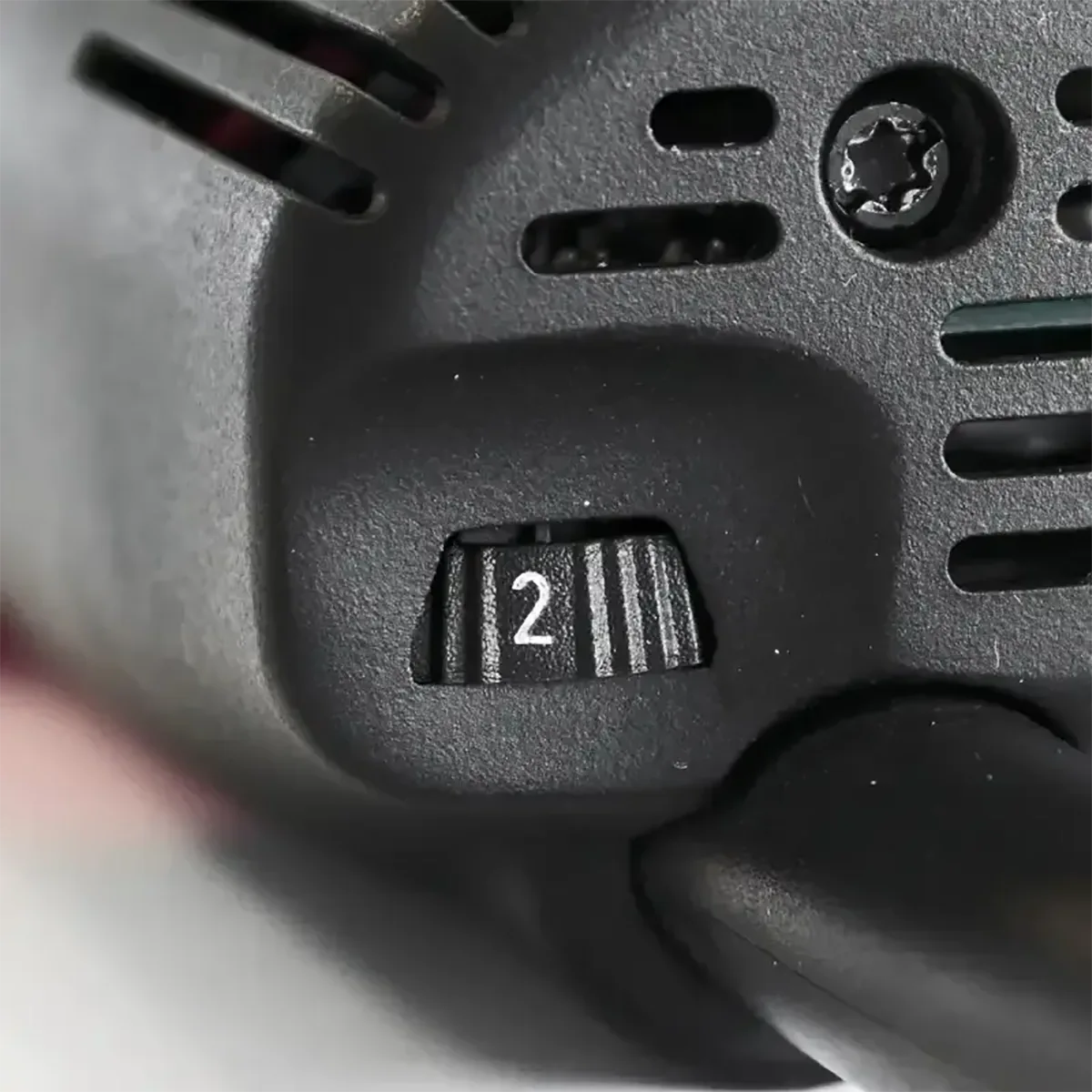 Eine Nahaufnahme des schwarzen Schalters, der beim Mafell FM 1000 PV-WS Fräsmotor - rot auf 2 eingestellt ist, zeigt die präzise Geschwindigkeitsregelung - ideal für präzises Arbeiten bei Modellbauprojekten.