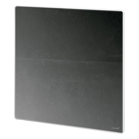 Eine schlichte, quadratische schwarze Fliese mit einer dezenten horizontalen Linie in der Mitte wird schräg dargestellt und bildet den idealen Rahmen für den HÜPPE Select+ Mirror Kosmetikspiegel – silber von HÜPPE – einen Dusch-Kosmetikspiegel, der für die Montage ohne Bohren konzipiert ist.