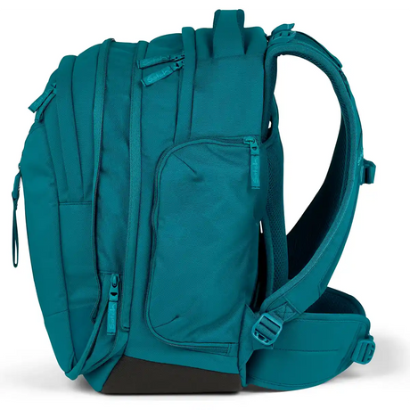 Der Satch Match Schulranzen - Deep Petrol von Satch zeichnet sich durch mehrere Fächer, Reißverschlüsse und gepolsterte Gurte aus, hier in der Seitenansicht. Dieser ergonomische Schulrucksack ist ideal für die weiterführende Schule.