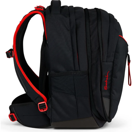 Seitenansicht des Satch Match Schulranzen - Fire Phantom von Satch in schwarz mit roten Akzenten, mit gepolsterten Trägern, mehreren Reißverschlussfächern und einem ergonomischen Schulrucksack-Design.
