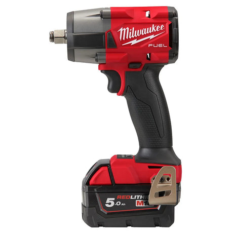 Der Milwaukee M18 FMTIW2F12-502X Schlagschrauber in rot, mit 2 Akkus, Ladegerät und Metall-Gürtelclip, bietet 881 Nm Drehmoment in kompakter Bauweise und ist seitlich abgebildet.