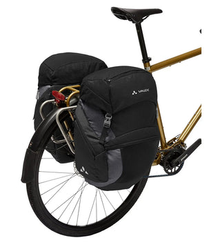 Die schwarze Vaude OnTour Fahrradtasche - schwarz von Vaude ist auf dem Gepäckträger eines goldenen Fahrrads montiert, von der Seite gesehen.