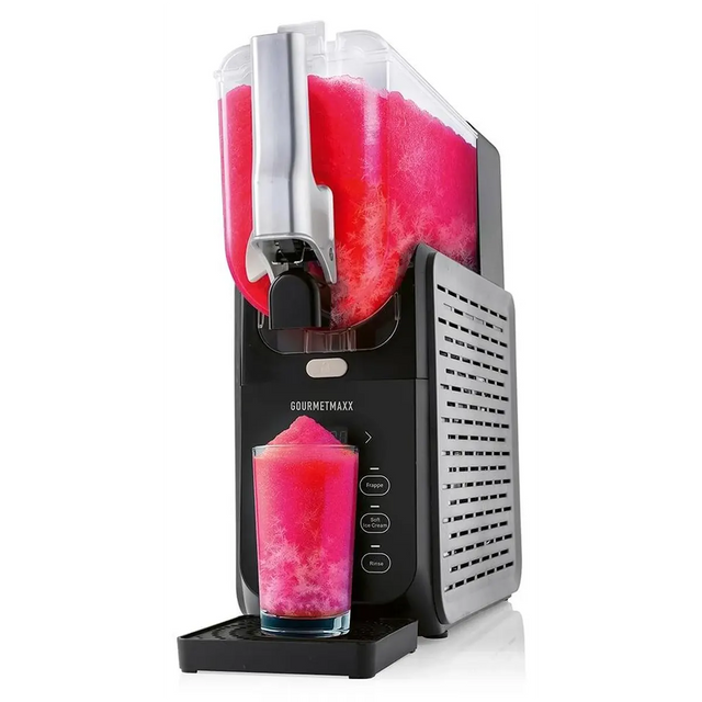 Die GOURMETmaxx FreezeUp Slush Eis Maschine - schwarz von GOURMETmaxx gibt ein rosa-weißes gefrorenes Getränk, ideal für Milchshakes oder Frozen Cocktails, in ein Glas auf der Tropfschale ab.