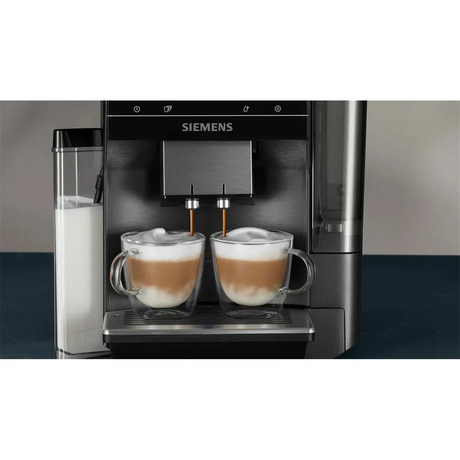 Ein Siemens EQ700 Integral TQ717DF5 Kaffeevollautomat – grau von Siemens, der zwei Cappuccinos mit sichtbarem Milchschaum zubereitet, serviert in Glasbechern.