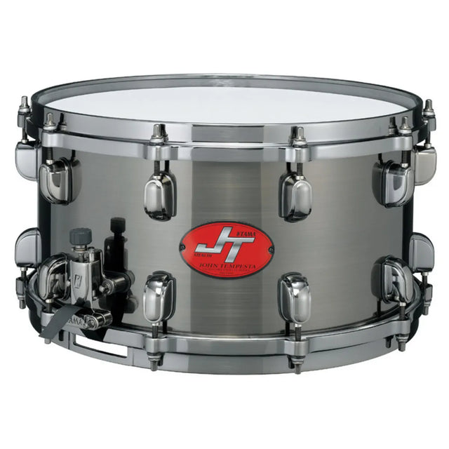 Die Tama John Tempesta JT147 Snare Drum - silber von Tama liefert kraftvolle, schneidende Töne und eine vielseitige Projektion, was sie ideal für Rock- und Metal-Drummer macht, die eine herausragende Snaredrum suchen.
