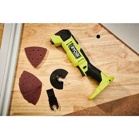 Ein Ryobi ONE+HP Akku-Multifunktionswerkzeug RMT18X-0 mit bürstenlosem Motor, Schleifpads und Aufsätzen der Marke Ryobi auf einer Holzoberfläche.