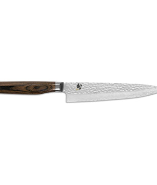 Das KAI Shun TDM-1701 Premier Tim Mälzer Allzweckmesser in Braun, mit einer Klinge aus gehämmertem Damaststahl und einem Griff aus dunklem Holz, wird vor einem weißen Hintergrund präsentiert.