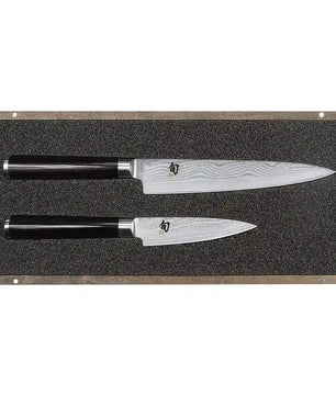 Zwei KAI DMS-200 Shun Tranchierset-Messer mit schwarzen Griffen liegen auf einer mit Schaumstoff ausgekleideten Ausstellungsplatte.