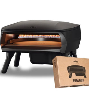 Der Witt PICCOLO Rotante 16 Pizzaofen - schwarz von Witt, mit sichtbaren Flammen und drehbarem Pizzastein, steht neben einem TOOLBOX-Karton mit dem passenden Produktbild.