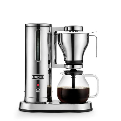 Die Aarke Filterkaffeemaschine – Edelstahl von Aarke brüht köstlichen Filterkaffee in eine Glaskanne, die vor einem weißen Hintergrund präsentiert wird.