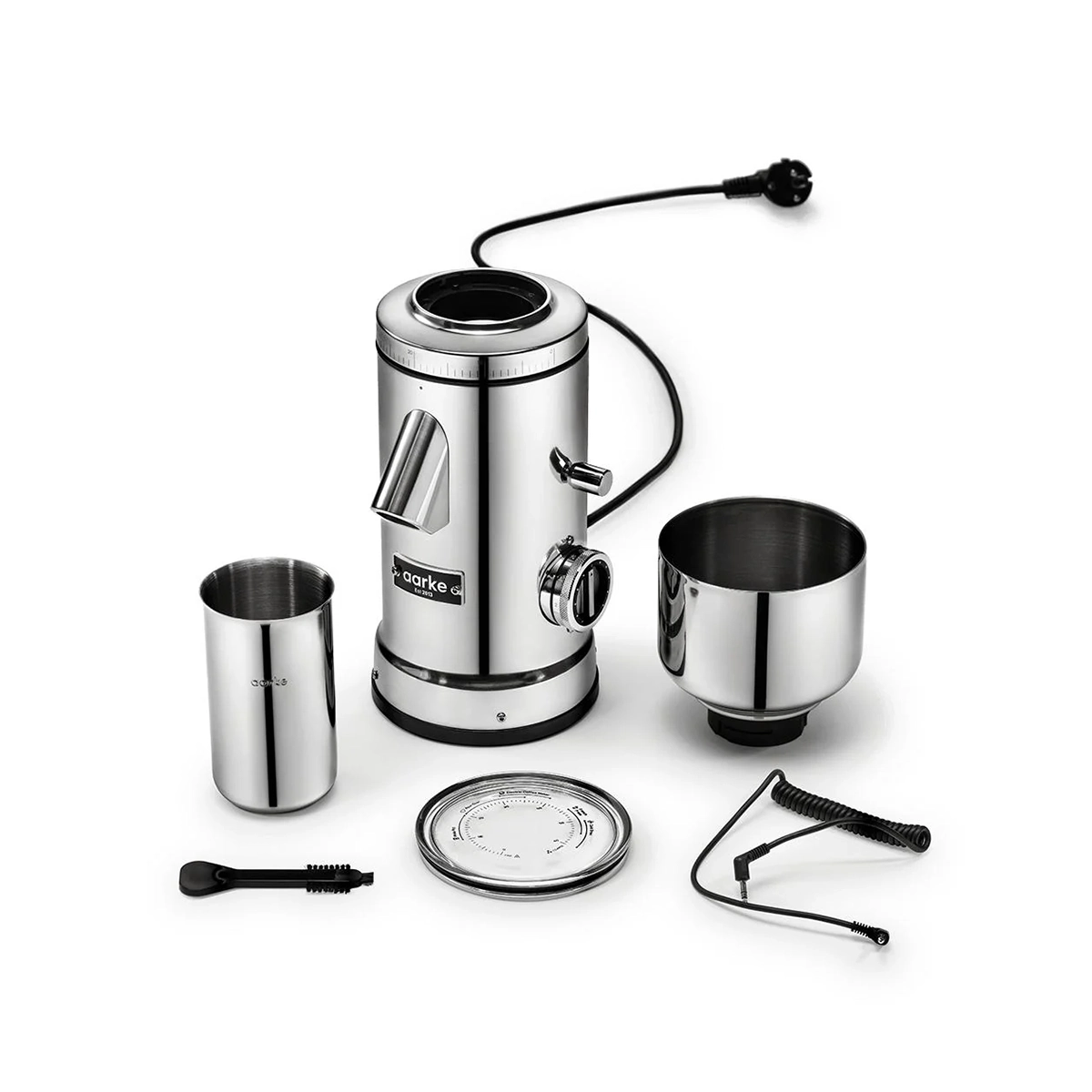 Aarke-Kaffeemühle – Edelstahl mit Zubehör, darunter Behälter, Bürste und Edelstahlkomponenten, präsentiert vor weißem Hintergrund. Dieses Set von Aarke, dessen Design von der Präzision einer Kaffeemühle mit konischem Edelstahlmahlwerk inspiriert ist, vereint Effizienz und zeitgenössisches Design, das an die ursprüngliche Aarke-Kaffeemühle erinnert.