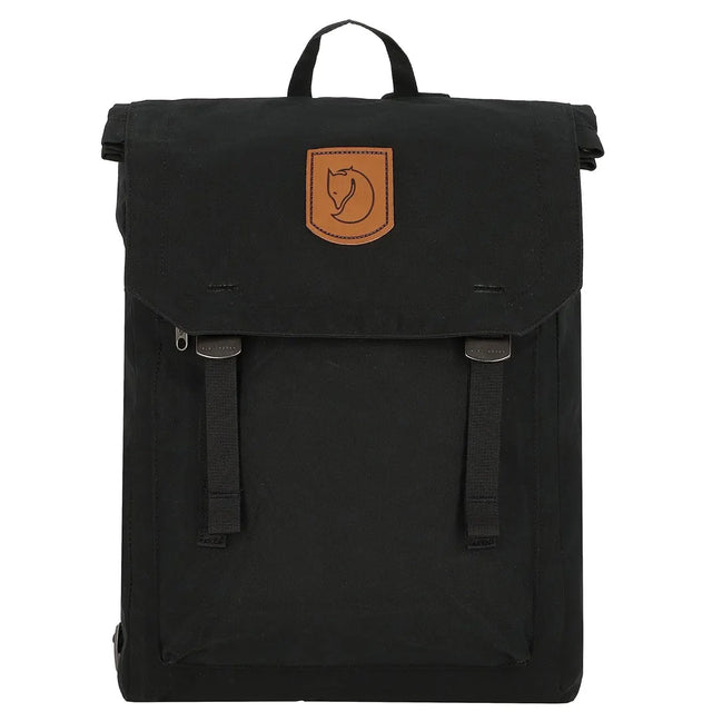 Der Fjällräven Totepack No. 1 Rücksack in schwarz mit braunem Leder-Logoaufnäher, zwei Schnallenriemen auf der Vorderseite und einem praktischen Laptopfach der Marke Fjällräven ist auf weißem Hintergrund abgebildet.