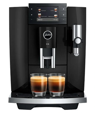 Der Jura E8 Kaffeevollautomat – schwarz brüht zwei Espressotassen mit cremigem Milchschaum und verfügt über ein digitales Display sowie elegante silberne Akzente.