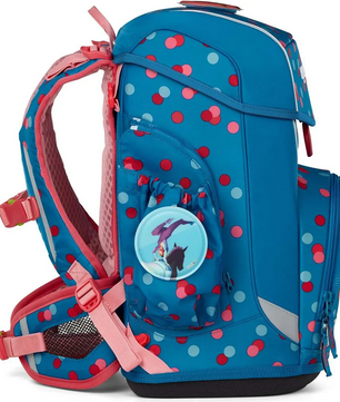 Das ergobag Cubo Light Set (2025) VoltiBär von ergobag hat blaue und pinke Punkte, pinke Gurte, ein Delphin-Abzeichen auf der Seitentasche und ist ergonomisch geformt für mehr Komfort.