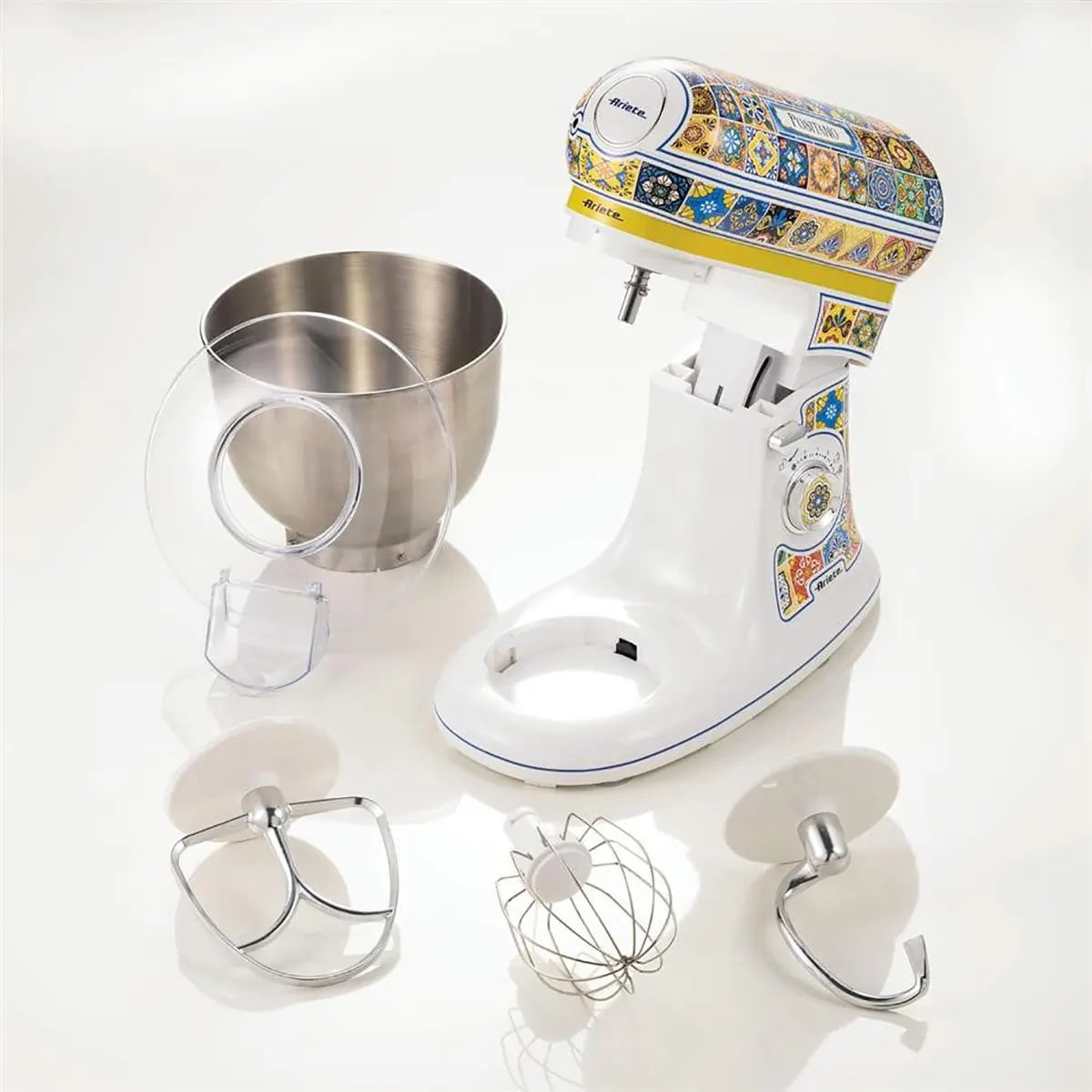 Die Ariete Küchenmaschine Positano überzeugt im modernen Design mit Planetenrührsystem, 5-Liter-Edelstahlschüssel und drei Metalllaufsätzen - stilvoll auf weißer Oberfläche.