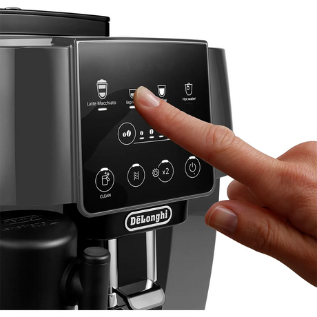 Eine Hand drückt die Espressotaste des De'Longhi Magnifica ECAM 223.61.GB Kaffeevollautomaten und unterstreicht damit seine intuitive Bedienung und das innovative LatteCrema Milchsystem.