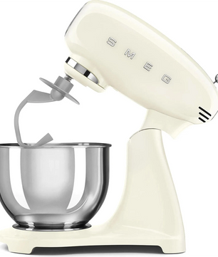 Die cremefarbene Smeg SMF03CREU Küchenmaschine mit einer 4,8-Liter-Edelstahlschüssel und einem Flachrührer, der schräg nach links ausgerichtet ist.