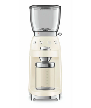 Die Smeg CGF01 Kaffeemühle in Creme besticht durch 50er-Jahre-Design, klaren Hopper und Glasbehälter - Barista-Qualität von Smeg, stilvoll vor weißem Hintergrund präsentiert.