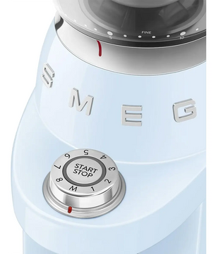 Nahaufnahme des Drehreglers der Smeg CGF03PBEU Kaffeemühle – blau – mit einstellbaren Stufen und einer Start-/Stopp-Taste, die ihr ikonisches Retro-Design unterstreicht. Diese Kaffeemühle von Smeg eignet sich perfekt zum Mahlen von Kaffeebohnen und vereint Stil und Präzision für das ultimative Kaffeeerlebnis.