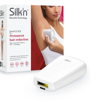Eine Frau verwendet das SILK'N Jewel LUXX Haarentfernungsgerät in Weiß mit HPL-Technologie; auf dem Bild sind das Gerät und die Originalverpackung der Marke SILK'N Jewel zu sehen.