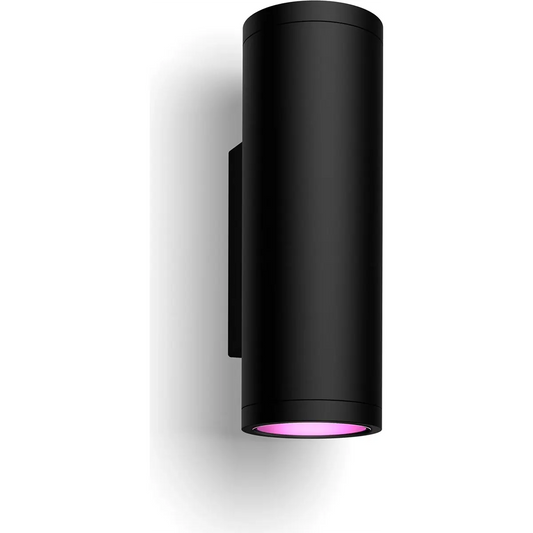 Die Philips Hue Outdoor Appear Wandleuchte - Schwarz von Philips ist eine schwarze, zylindrische Wandleuchte, die ein sanftes, rosafarbenes Licht nach unten abstrahlt und Ihren Außenbereich elegant und intelligent beleuchtet.