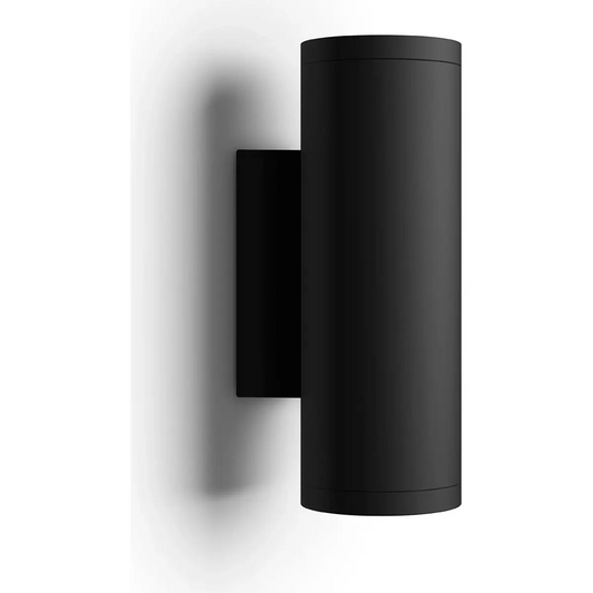 Die Philips Hue Outdoor Appear Wandleuchte in Schwarz von Philips ist an einer weißen Wand angebracht und wirft einen dezenten Schatten.