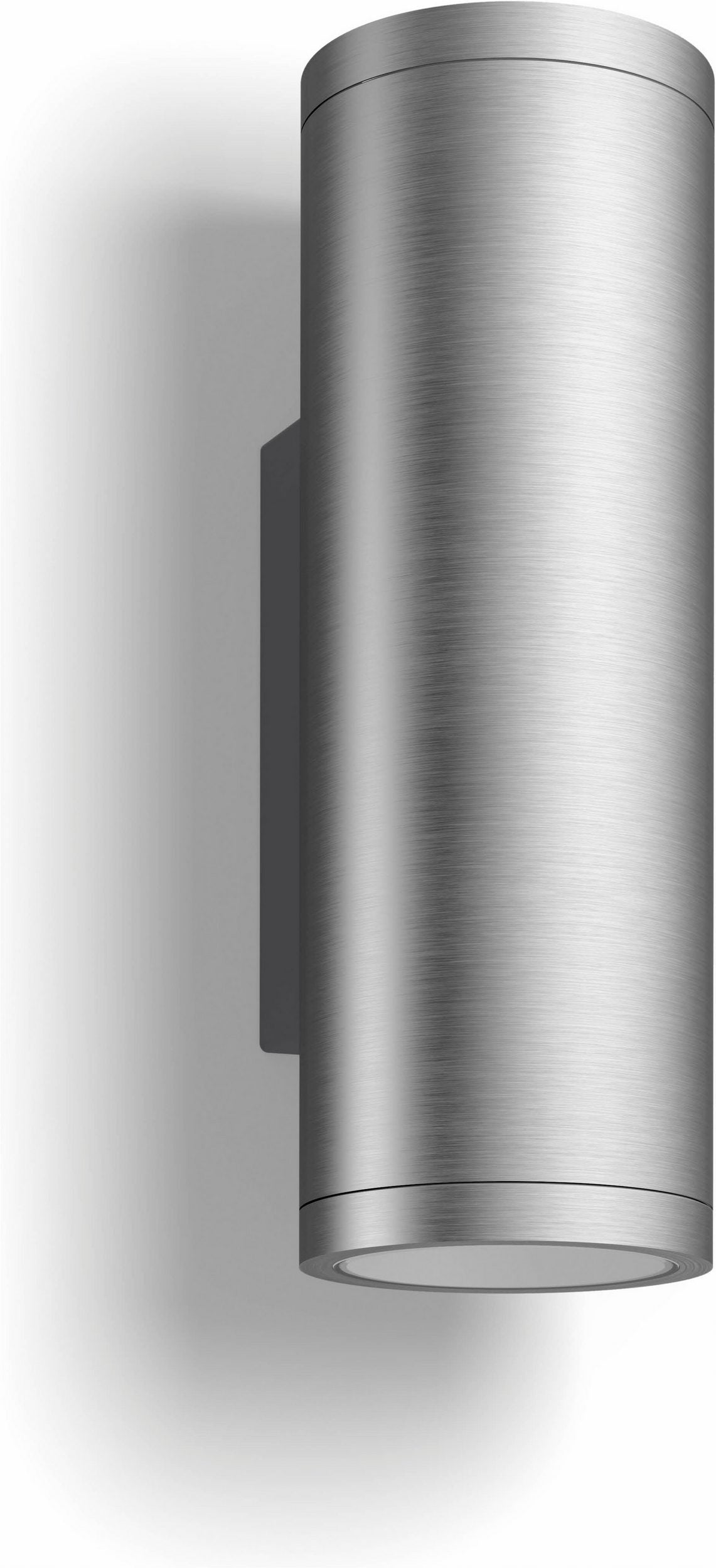 Eine zylindrische Wandleuchte aus gebürstetem Metall, wie beispielsweise die „Philips Hue Appear Ambiance Außenwandleuchte“ in Silber von Philips, wirft einen auffälligen Schatten auf eine weiße Wand – ideal, um Ihre Smart-Home-Beleuchtung aufzuwerten.