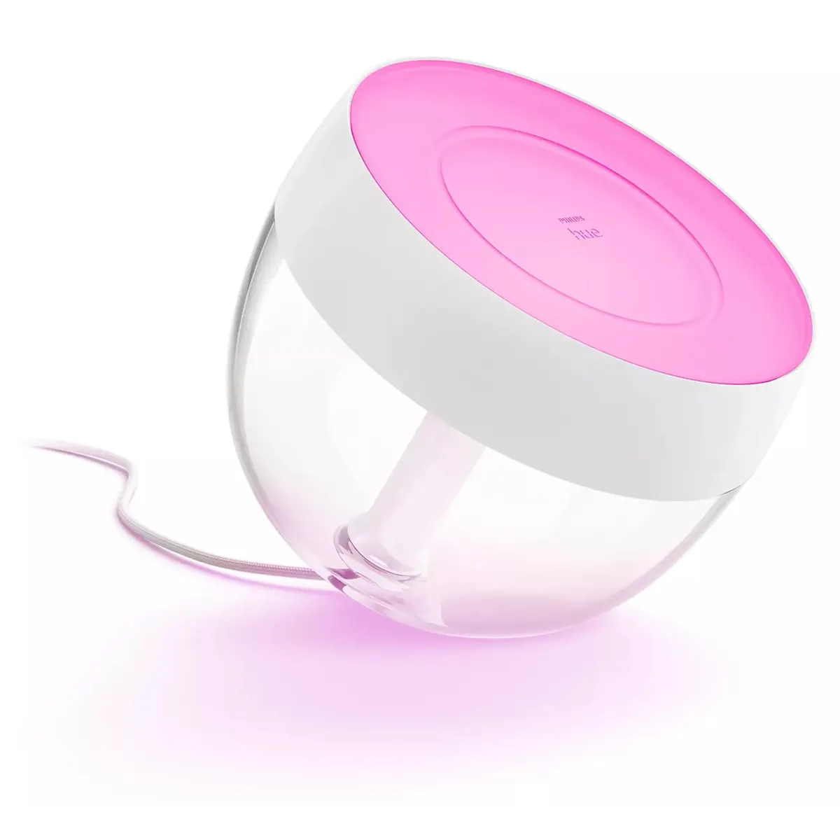 Die Philips Hue Ambiance Iris Tischleuchte – weiß von Philips besticht durch ihr rundes Design mit einer rosa Oberseite und strahlt ein sanftes rosa Licht aus, das für eine gemütliche Stimmungsbeleuchtung sorgt, wenn sie über ein weißes Kabel an die Steckdose angeschlossen ist.